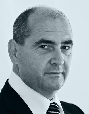 Der Anwalt Sebastian Müller  in Anzug und Krawatte blickt ernsthaft, repräsentiert DIE KANZLEI MÜLLER & KOLL. im Bereich Zivilrecht.